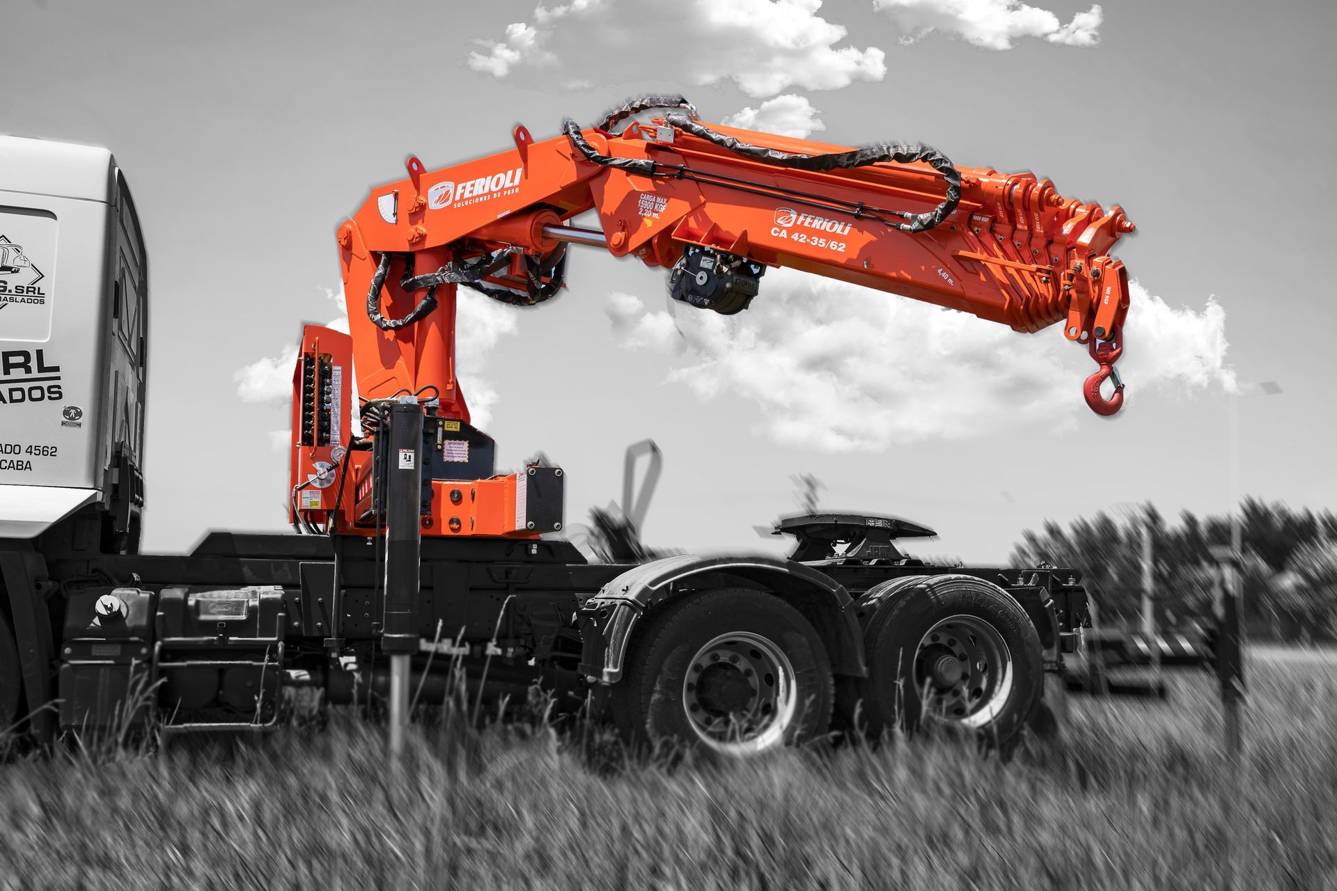 Orange crane arm attached to a truck, set against a black and white landscape background.